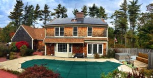 back of home in plymouth, ma with a pool and a rooftop solar insulation.