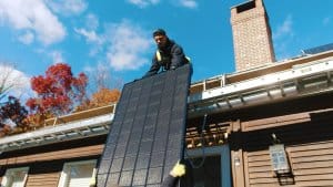 My Generation Energy solar installation team lifting solar panels onto residential rooftop
