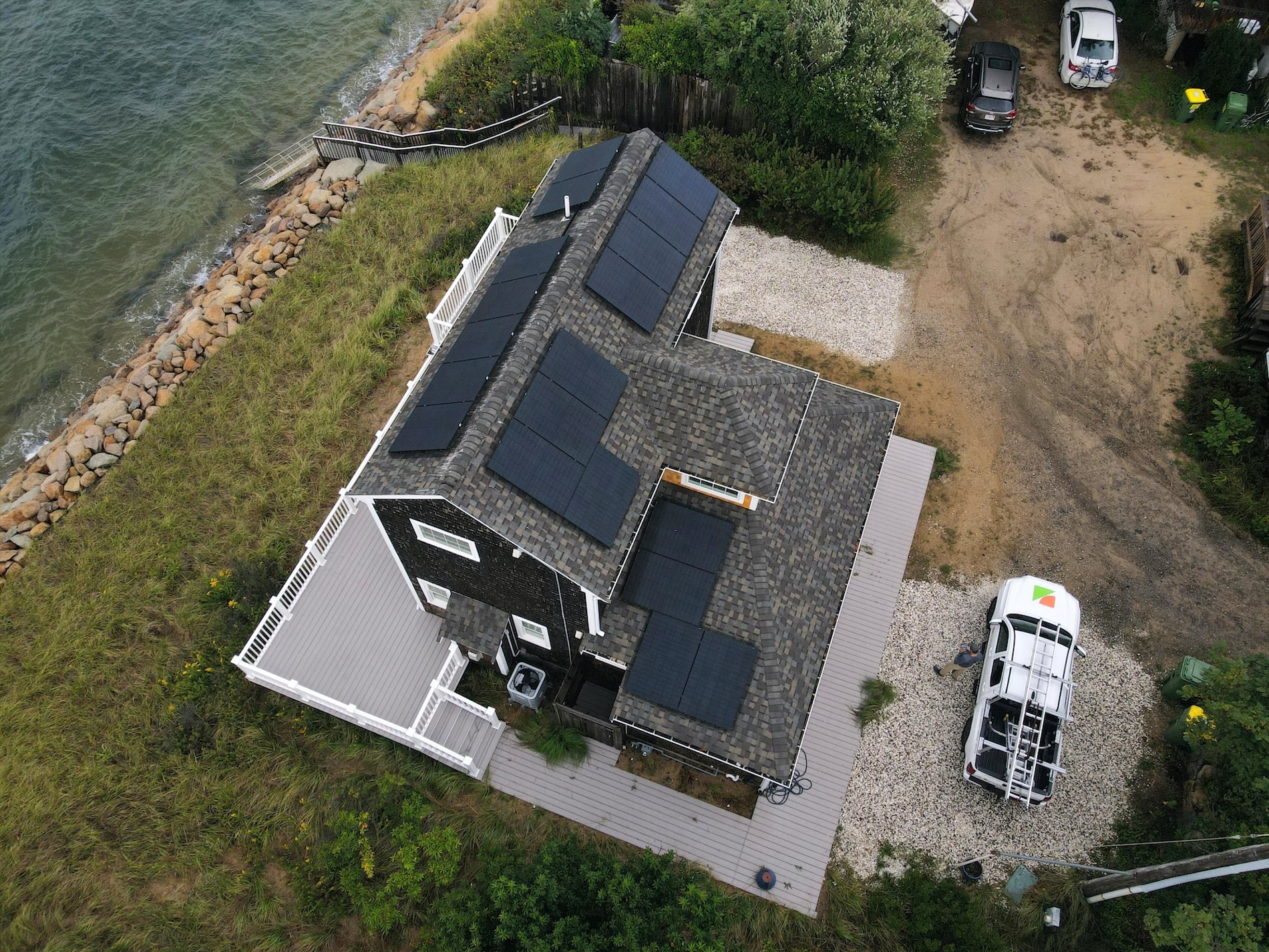 Dark brown house with rooftop solar panels on the shore