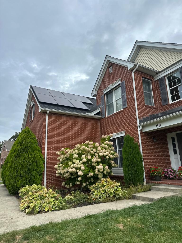 brick home in the summer with rooftop solar panels